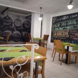 Imagen de las mesas del comedor de La Bancada, con atención a la pizarra donde se incluyen promociones activas